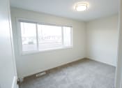 Thumbnail 8 of 18 - an empty bedroom with a large window and carpeting