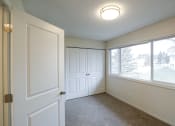 Thumbnail 11 of 18 - an empty living room with a large window and a white door