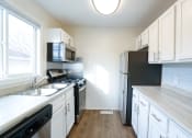 Thumbnail 14 of 18 - a kitchen with white cabinets and stainless steel appliances and a window