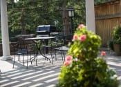 Thumbnail 31 of 49 - a patio with tables and chairs and an outdoor grill
