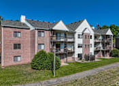 Thumbnail 41 of 54 - Apartment complex with red brick building and white building with balconies.