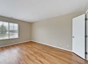 Thumbnail 31 of 36 - an empty living room with wood floors and a window