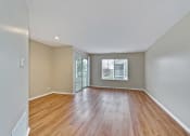 Thumbnail 30 of 36 - an empty living room with wood floors and a window