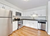 Thumbnail 28 of 36 - a kitchen with white cabinets and stainless steel appliances
