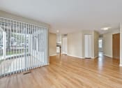 Thumbnail 27 of 36 - an empty living room with a wood floor and a window