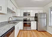Thumbnail 26 of 36 - a kitchen with white cabinets and stainless steel appliances