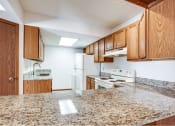 Thumbnail 26 of 36 - a kitchen with white appliances and granite counter tops