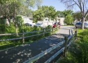 Thumbnail 30 of 36 - a street with a fence and cars parked in front of houses