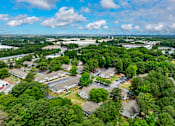 Thumbnail 9 of 19 - A bird's eye view of a residential area surrounded by trees.