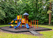 Thumbnail 7 of 19 - A playground with a yellow slide and a blue slide.