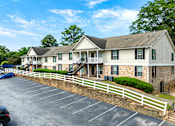 Thumbnail 4 of 19 - A building with a parking lot in front of it.