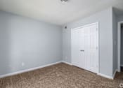Thumbnail 13 of 19 - A room with a white door and carpeted floor.