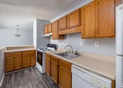 Thumbnail 12 of 19 - A kitchen with wooden cabinets and a white refrigerator.