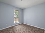 Thumbnail 10 of 19 - A room with a carpeted floor and a window.