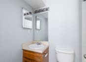 Thumbnail 17 of 19 - A bathroom with a sink, toilet, and mirror.