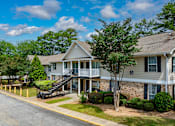 Thumbnail 3 of 19 - A residential building with a tree in front.