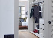 Thumbnail 14 of 15 - A white door with a black handle is open to a hallway with a coat rack.