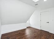 Thumbnail 34 of 36 - A room with a wooden floor and white walls.