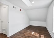 Thumbnail 36 of 36 - A room with a white door and a window on the right side.