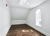 Thumbnail 29 of 36 - A room with a window and a wooden floor.