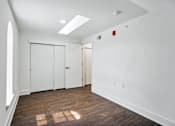 Thumbnail 32 of 36 - A room with white walls and wood flooring with a skylight.