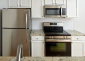 Thumbnail 2 of 13 - a kitchen with stainless steel appliances and white cabinets