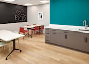 Thumbnail 47 of 54 - A room with a white table and chairs and a blackboard with the words "GO BIRDS" written on it.