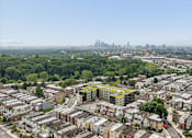 Thumbnail 31 of 31 - A cityscape with a mix of residential and commercial buildings, with a clear sky and a distant city skyline.