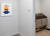 Thumbnail 50 of 54 - A painting of a stack of shapes is on the wall in a white room.