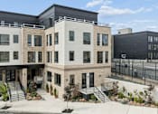 Thumbnail 1 of 31 - A modern building with a black fence in front.