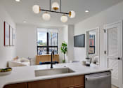 Thumbnail 2 of 15 - A modern kitchen with a large island and a view of the city.