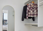 Thumbnail 5 of 15 - A white suitcase is on the floor next to a wall-mounted closet.