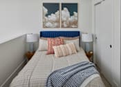 Thumbnail 12 of 24 - A bed with a blue headboard and a white comforter with a blue and white checkered blanket on it. at 23 West Apartments, Philadelphia, PA