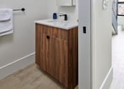 Thumbnail 10 of 24 - A bathroom with a white sink and a wooden cabinet. at 23 West Apartments, Philadelphia, PA