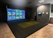Thumbnail 9 of 17 - A room with a large screen displaying a video game.