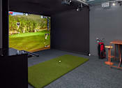 Thumbnail 44 of 54 - A golf simulator room with a screen and a mat.
