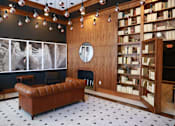 Thumbnail 9 of 32 - A living room with a brown leather couch and a fireplace.