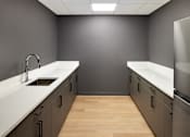 Thumbnail 49 of 54 - A kitchen with a white counter top and wooden floors.