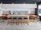 Thumbnail 16 of 23 - A modern bar area with a white counter and black stools. at The Weaver, Philadelphia, PA, 19125