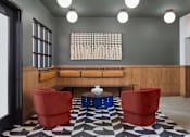 Thumbnail 14 of 23 - A black and white checkered floor in a room with a wooden bench and red chairs. at The Weaver, Philadelphia, PA, 19125