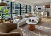 Thumbnail 3 of 15 - A modern living room with a large window overlooking a cityscape.