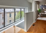 Thumbnail 9 of 13 - a living room with a large window and a wooden floor