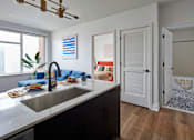 Thumbnail 4 of 17 - Living room and kitchen with wood flooring at The Weaver, Philadelphia, PA