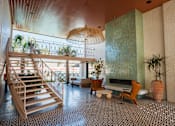 Thumbnail 4 of 30 - A wooden staircase with a glass railing leads to a balcony at The PARKER on E Mulberry Apartments, San Antonio, Texas