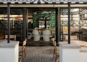 Thumbnail 16 of 30 - A restaurant with a black and white striped awning and a mosaic tile floor at The PARKER on E Mulberry Apartments, San Antonio, TX, 78209