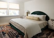 Thumbnail 23 of 30 - A bedroom with a large bed and a patterned rug at The PARKER on E Mulberry Apartments, Texas