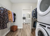 Thumbnail 66 of 87 - a laundry room with a washer and dryer and a door to a bathroom at Beekman on Broadway, Ann Arbor, MI, 48105