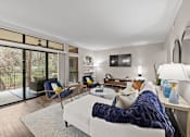 Thumbnail 3 of 48 - Modern living room with navy accents and balcony access at Nalle Woods of Westlake Apartments, Texas
