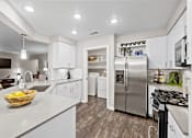 Thumbnail 1 of 48 - Modern kitchen with white cabinetry and island at Nalle Woods of Westlake Apartments, Texas, 78746