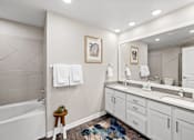 Thumbnail 8 of 48 - Modern bathroom with dual vanity and soaking tub at Nalle Woods of Westlake Apartments, Texas